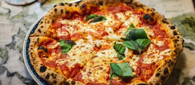 What is the traditional shape of a Neapolitan pizza?